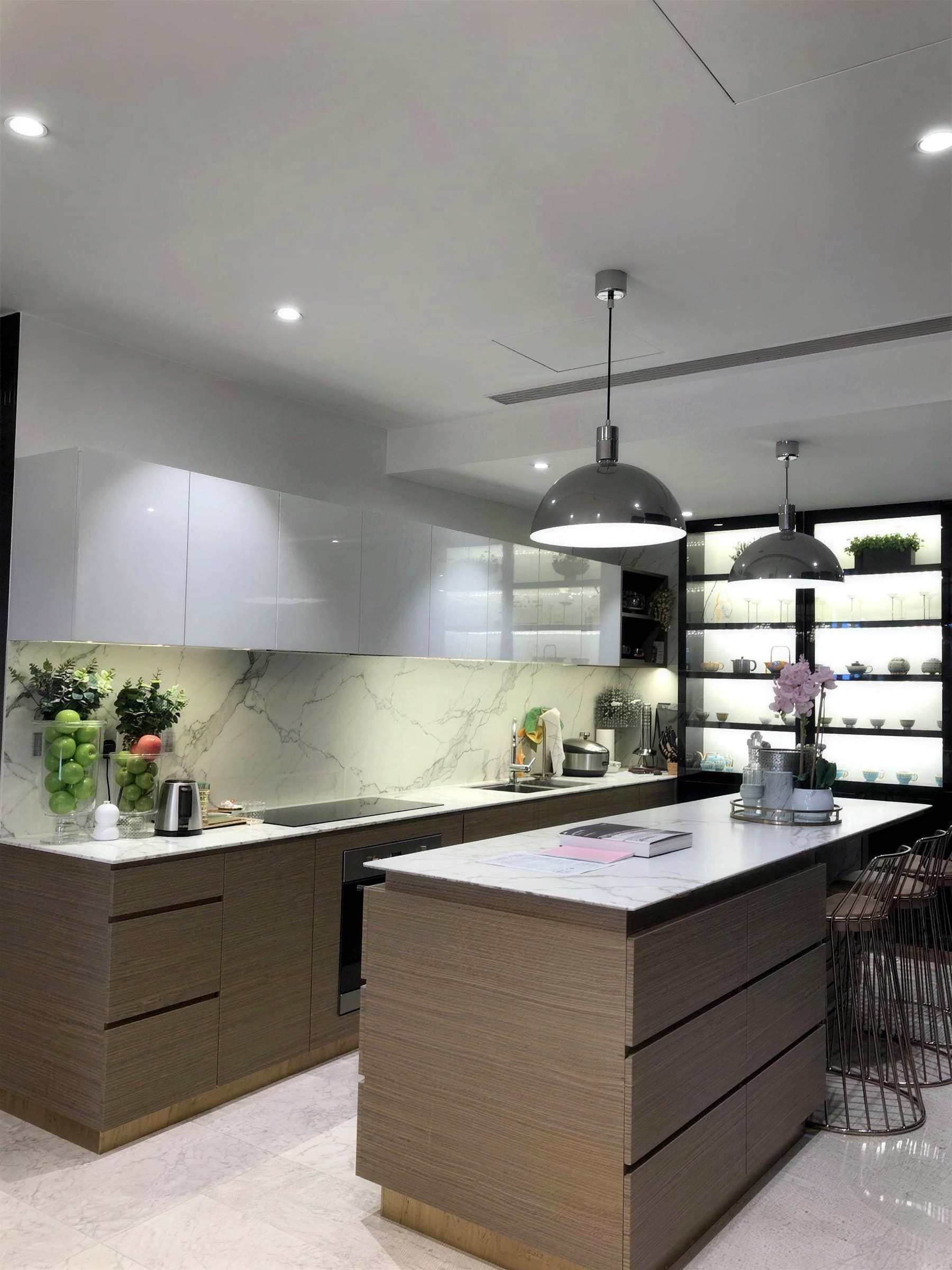 Kitchen with custom island, marble backsplash and lit display cabinet