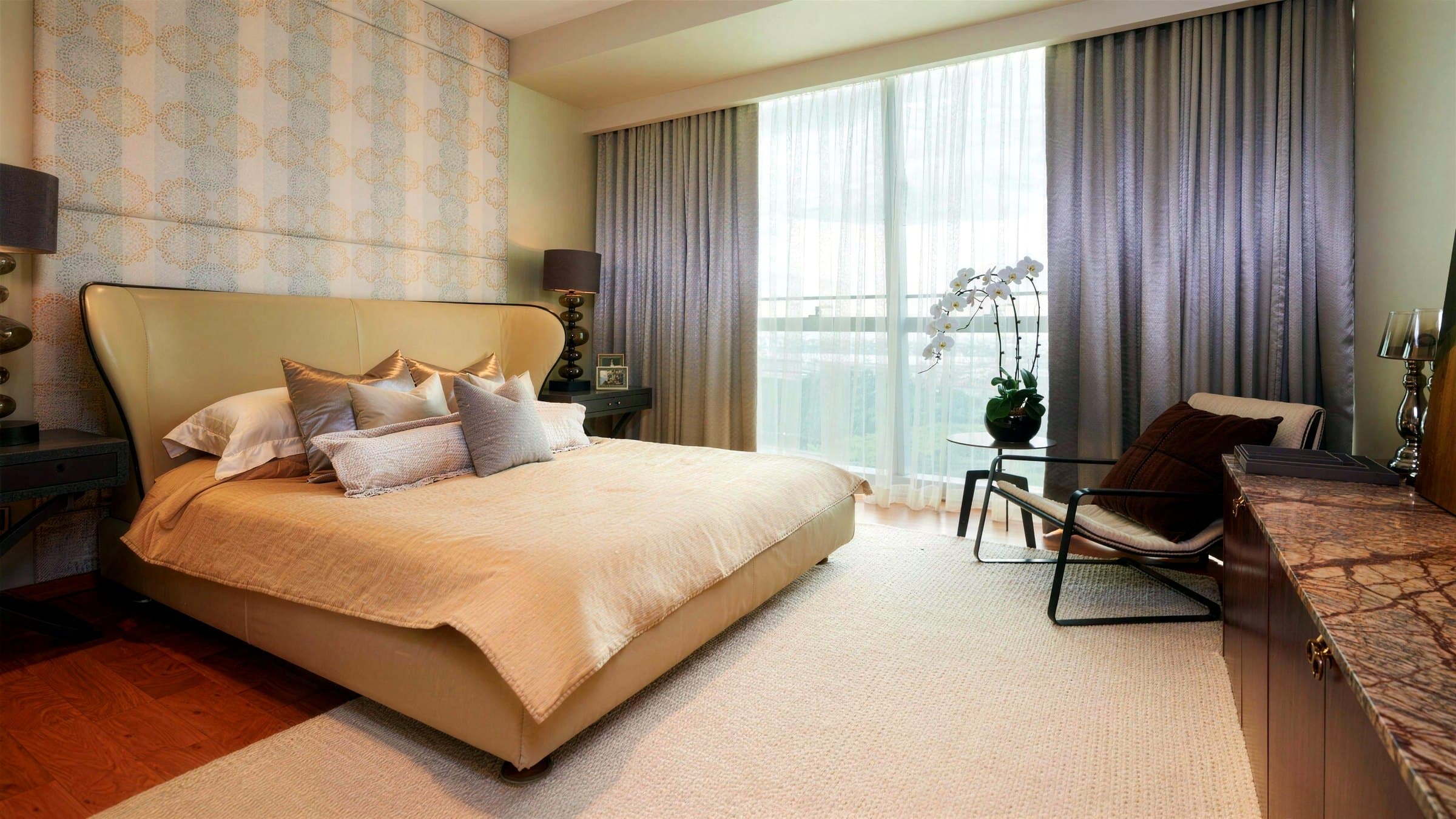 Master bedroom with a patterned feature wall behind the bed