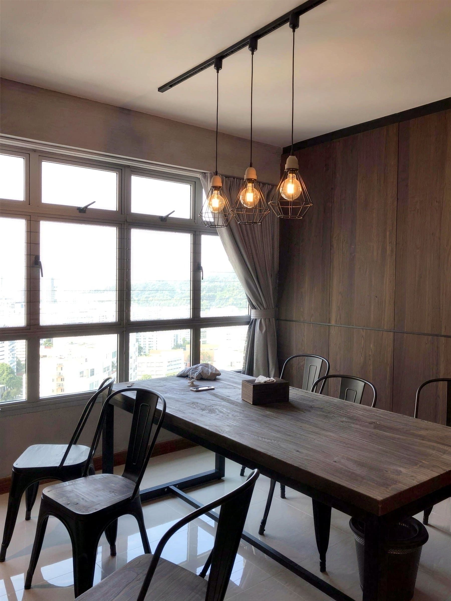 Dining table by the window under caged pendant lights