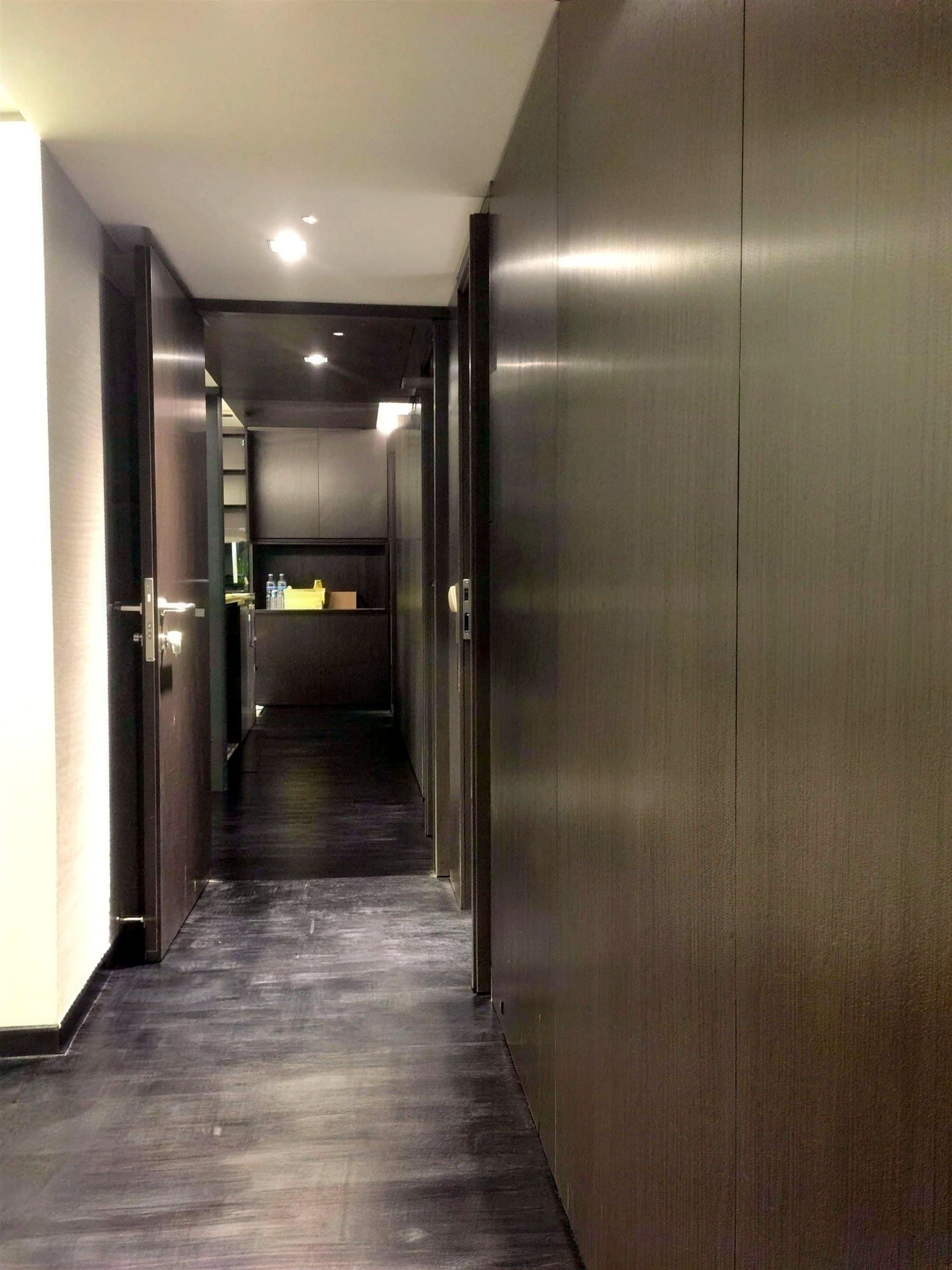 Corridor lined in dark timber panelling and flush doors