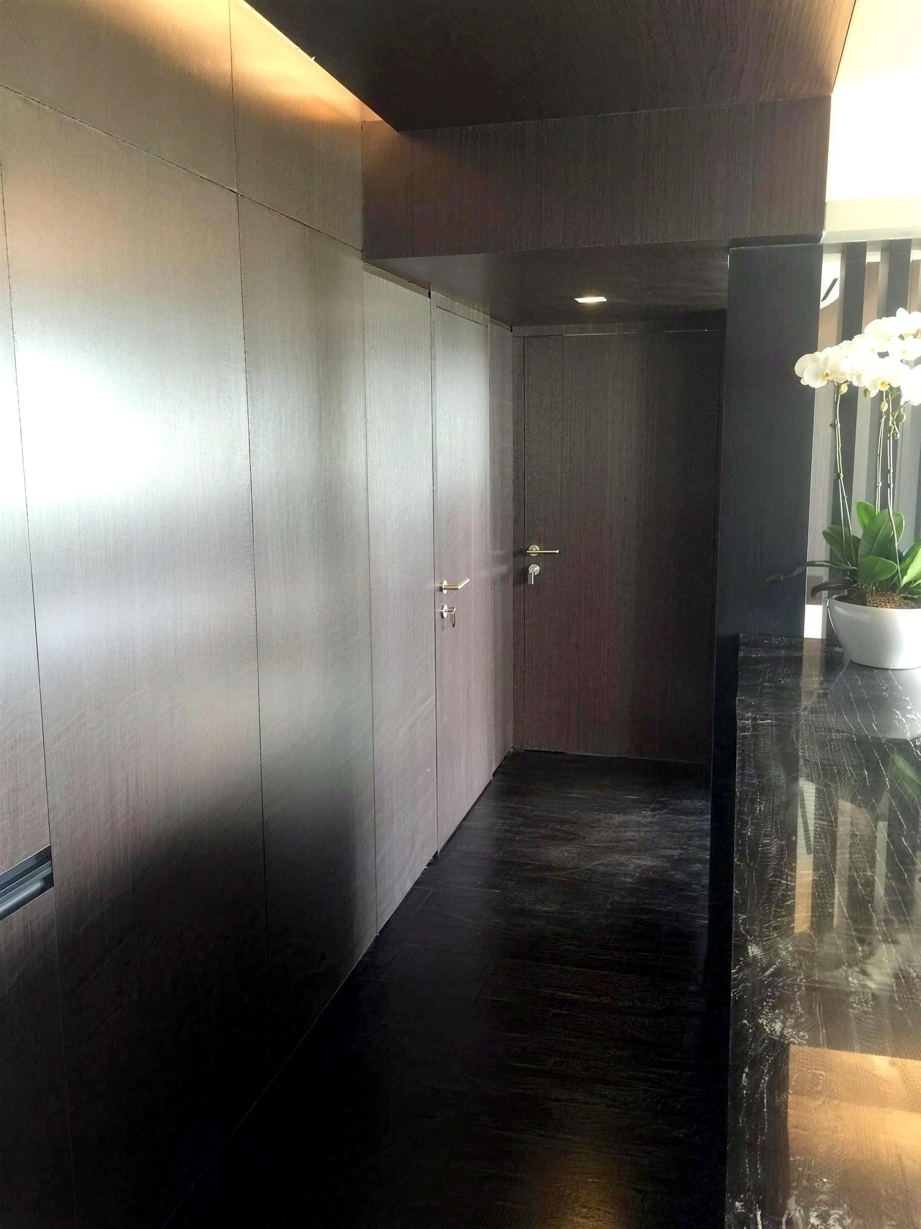 Entry with dark timber panelling and stone-look counter