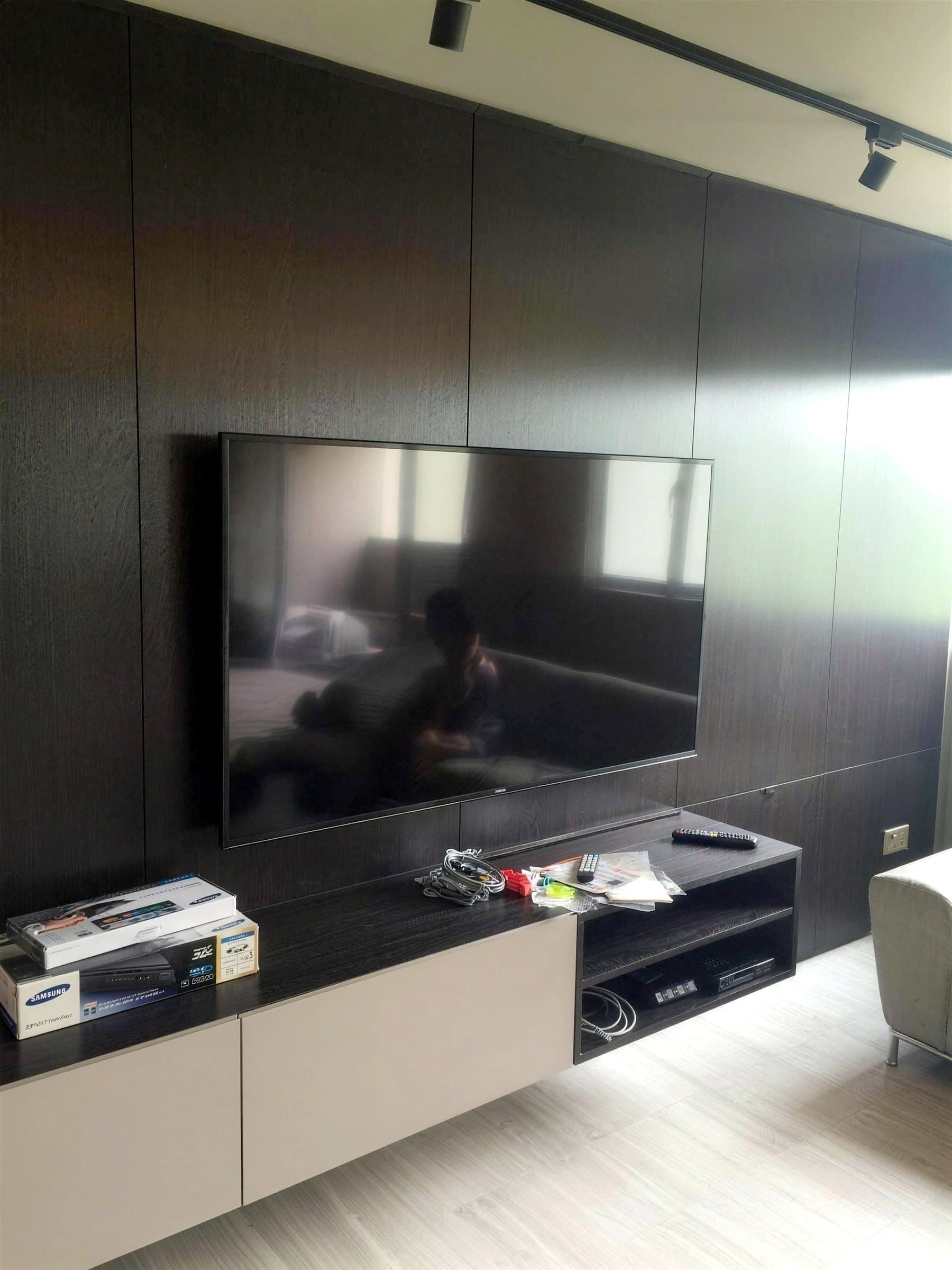 Ang Mo Kio living room with a dark wood-panelled TV feature wall and taupe sideboard