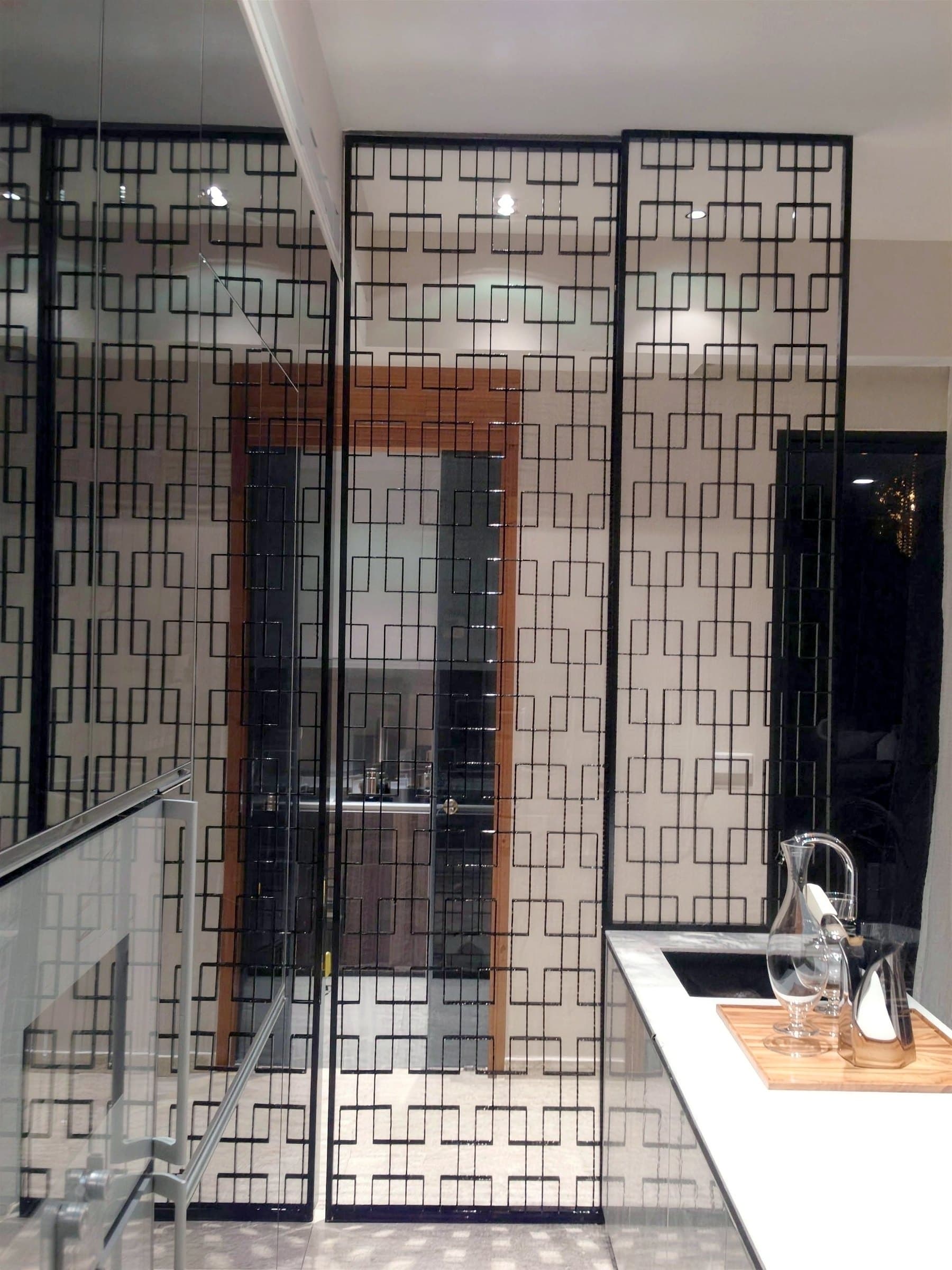 Black laser-cut fretwork screen beside the dry-kitchen counter