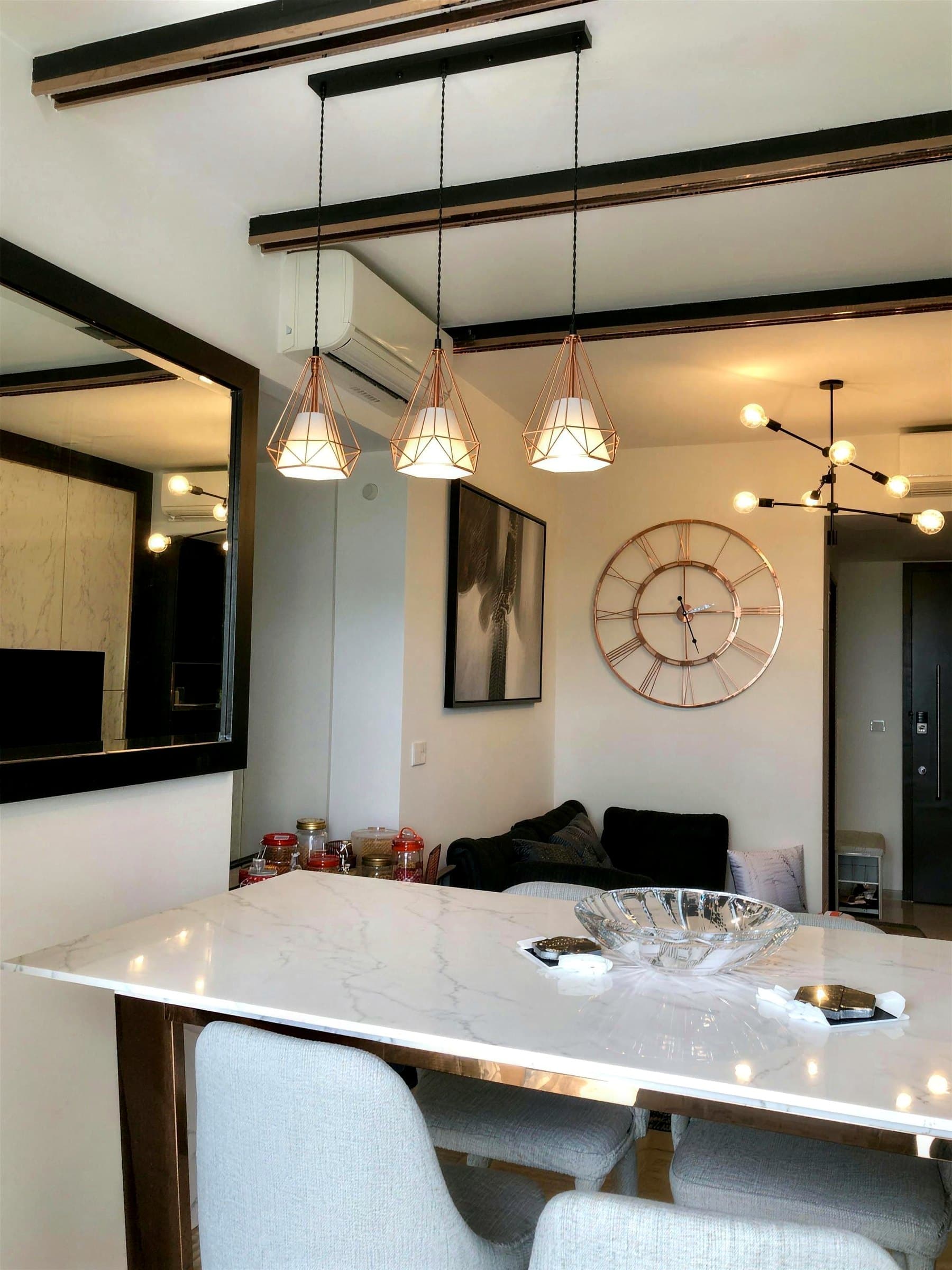 Dining area with black millwork and copper-wire cage pendants