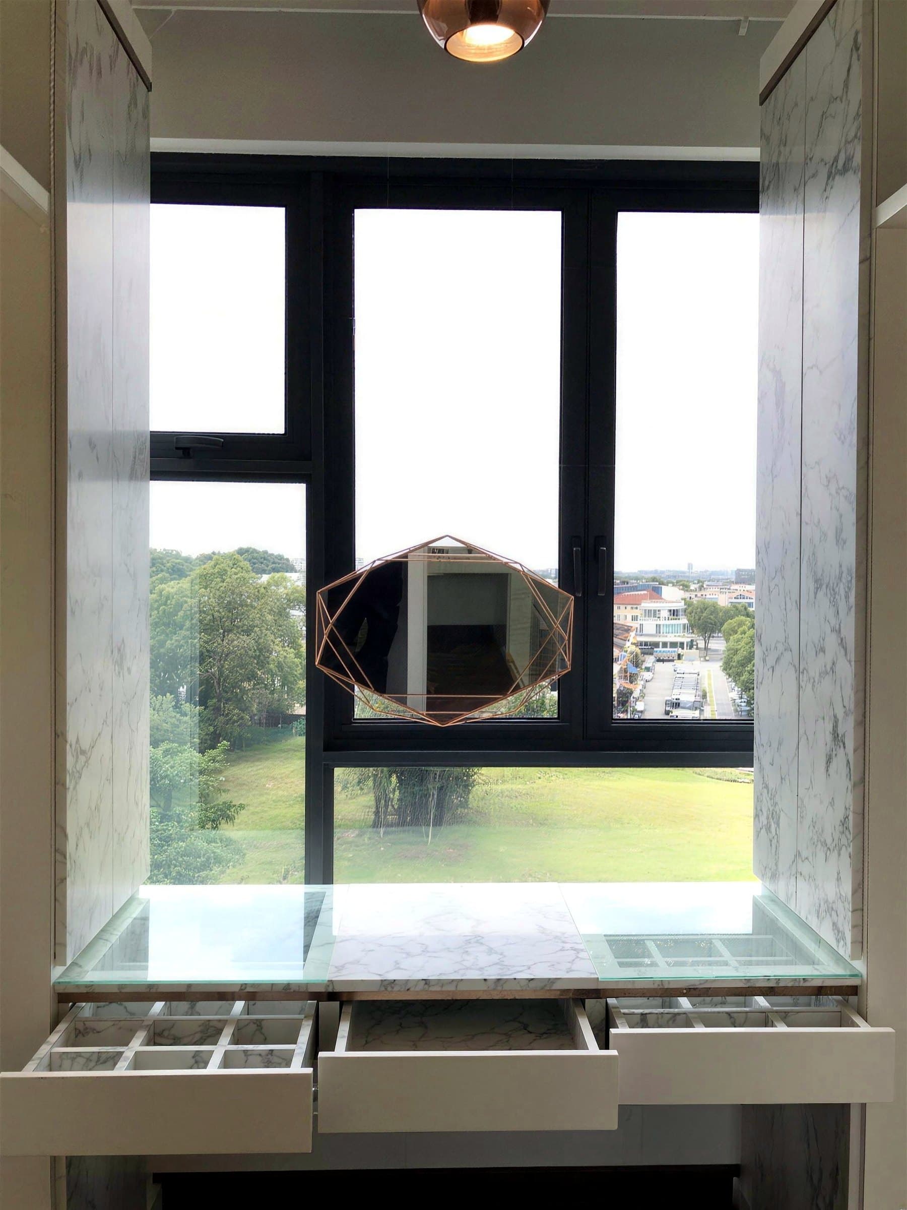 Built-in dressing table at the window with a marble-look top