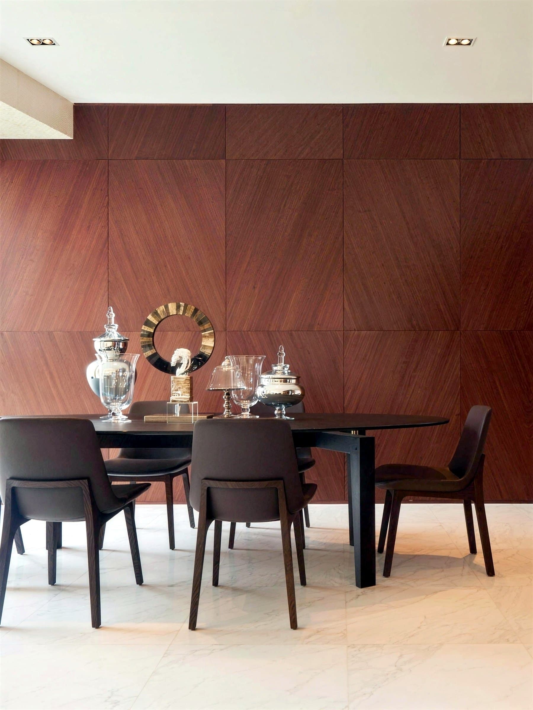 Dining area in front of a timber-veneer feature wall