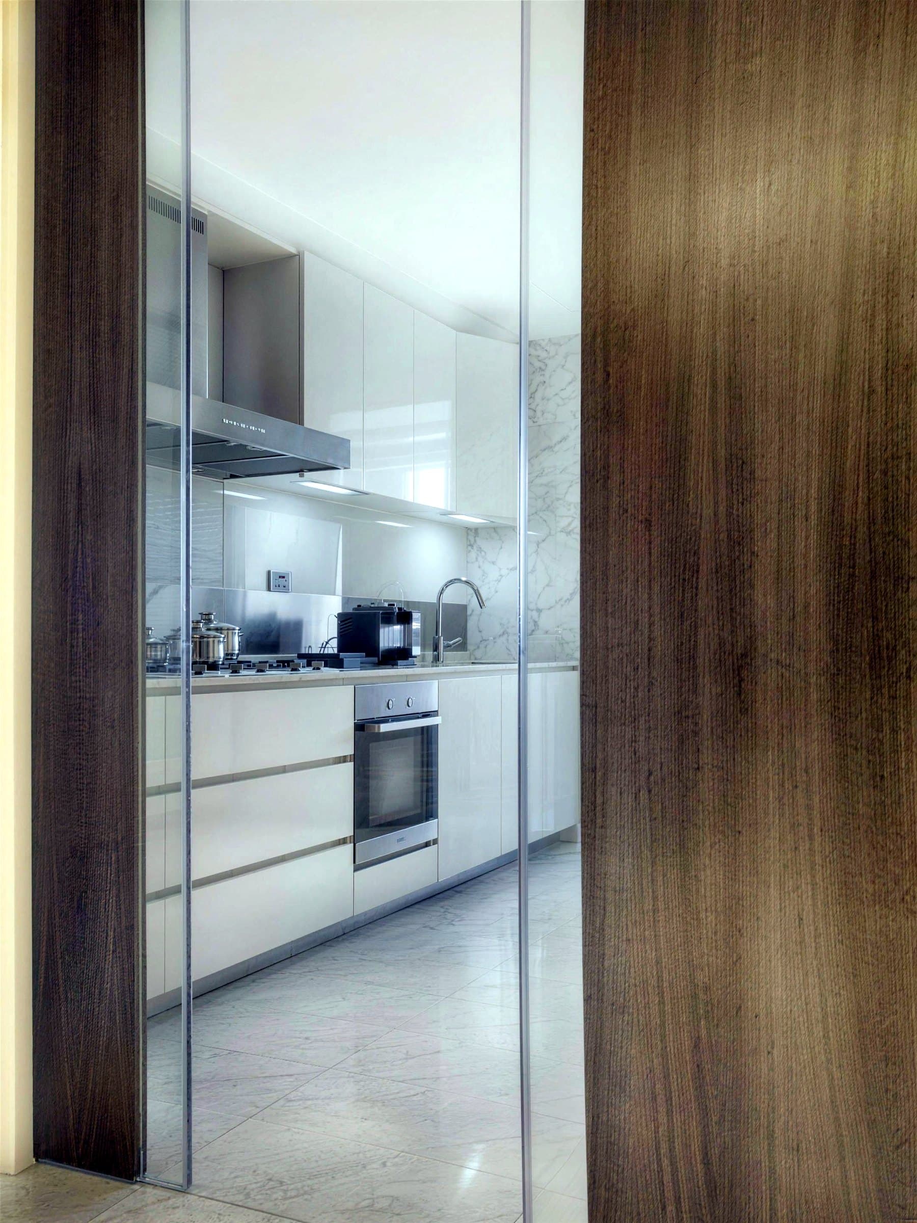 Kitchen seen through a full-height timber and glass sliding door