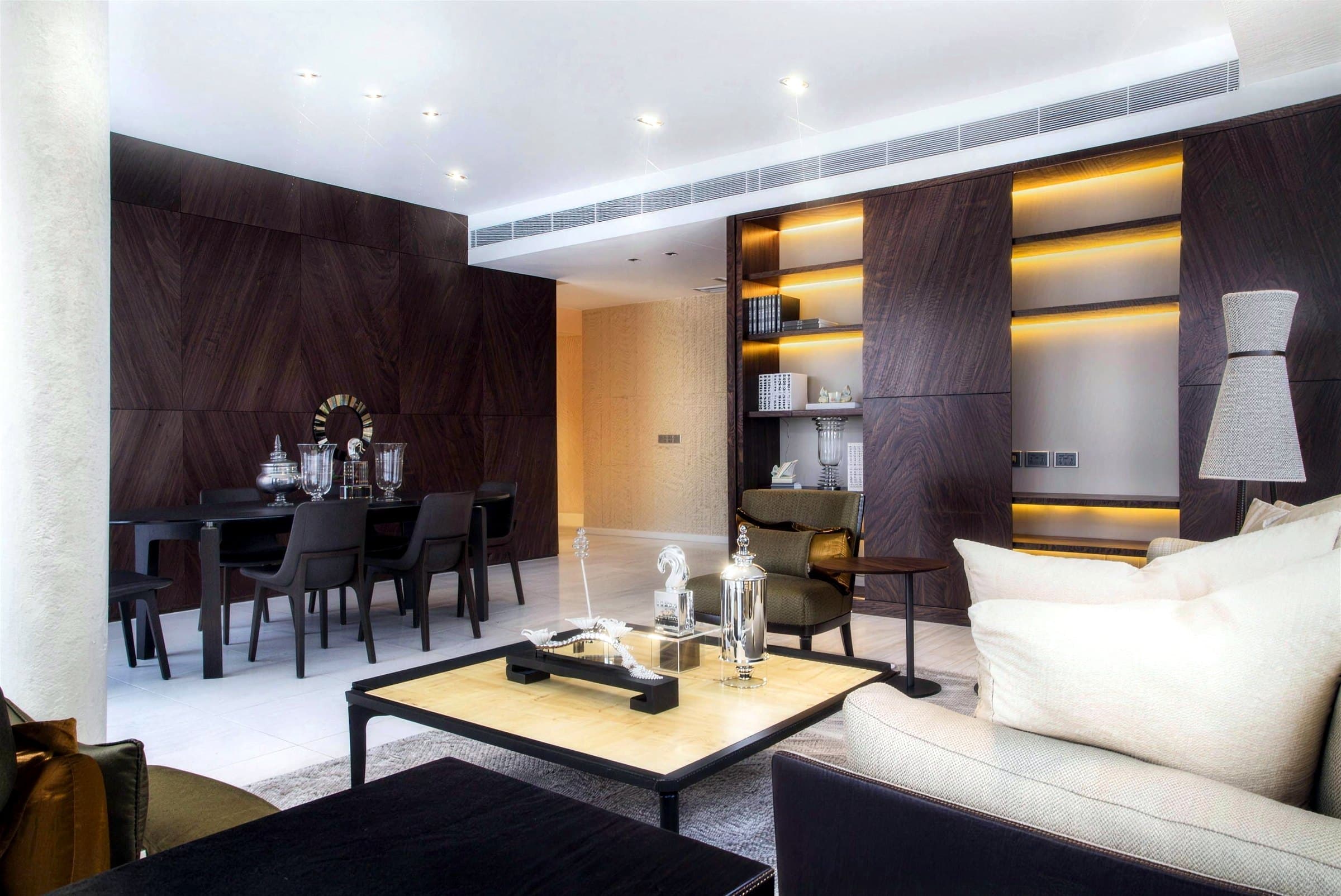 Reflections at Keppel Bay living and dining area with timber-veneer wall panelling, backlit shelving and marble floor