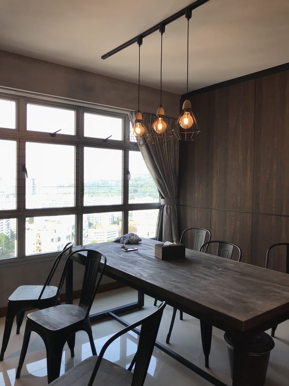 Dining table by the window under caged pendant lights
