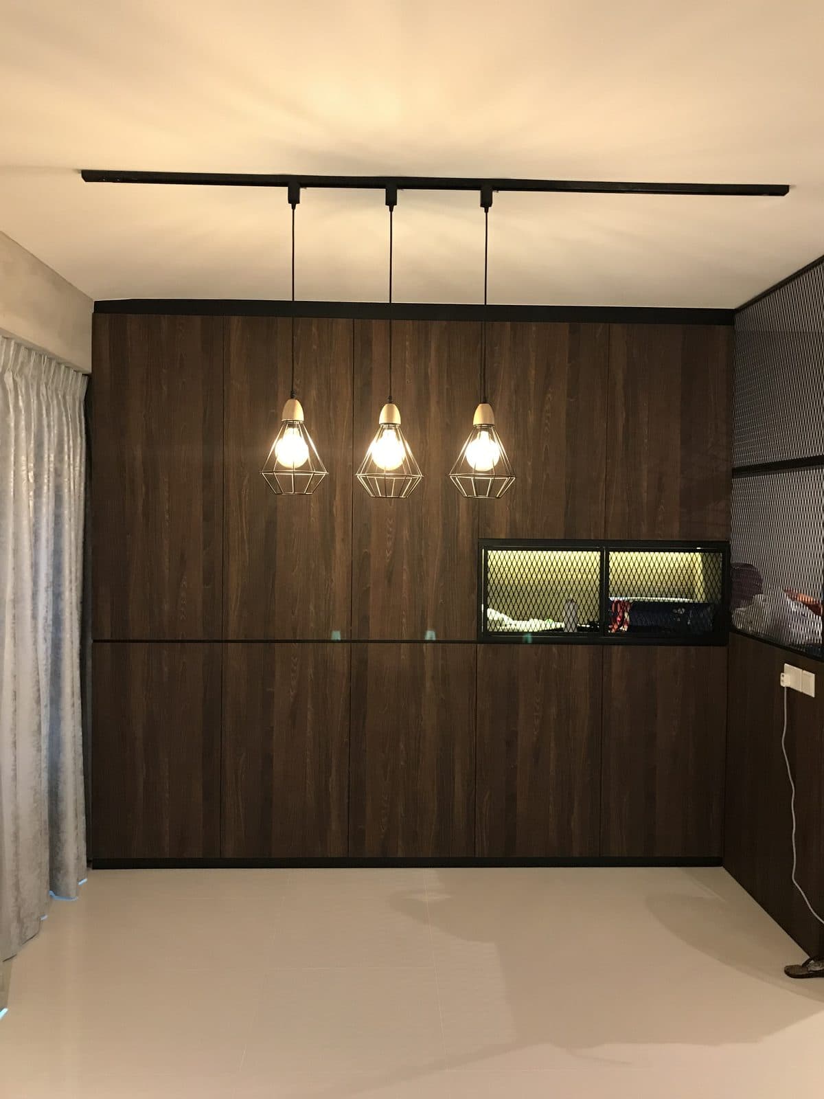 Skypeak living room with dark timber feature wall and caged pendant lights