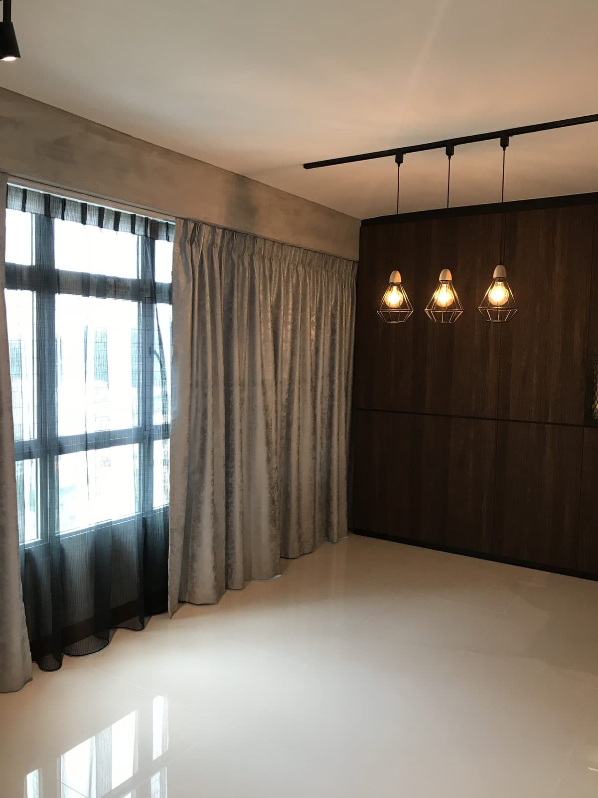 Living room with exposed track lighting and curtains