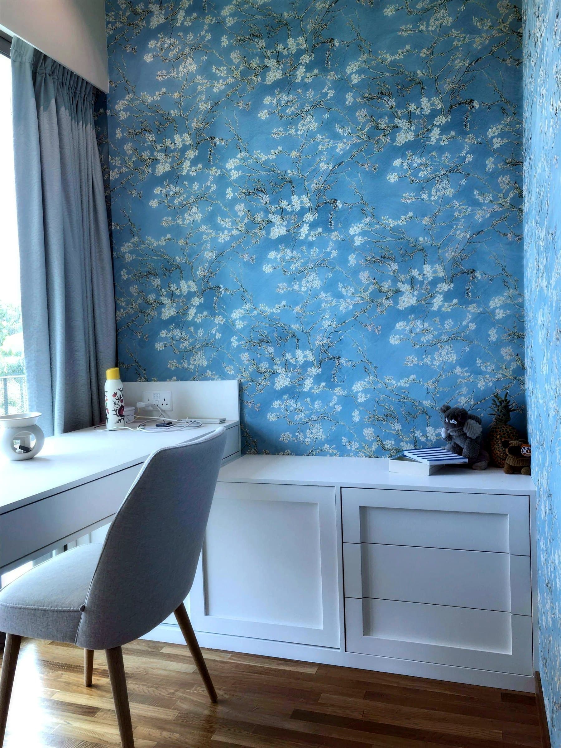 Tangerine bedroom wallpapered wall-to-ceiling in Almond Blossom, with a built-in desk and cabinets