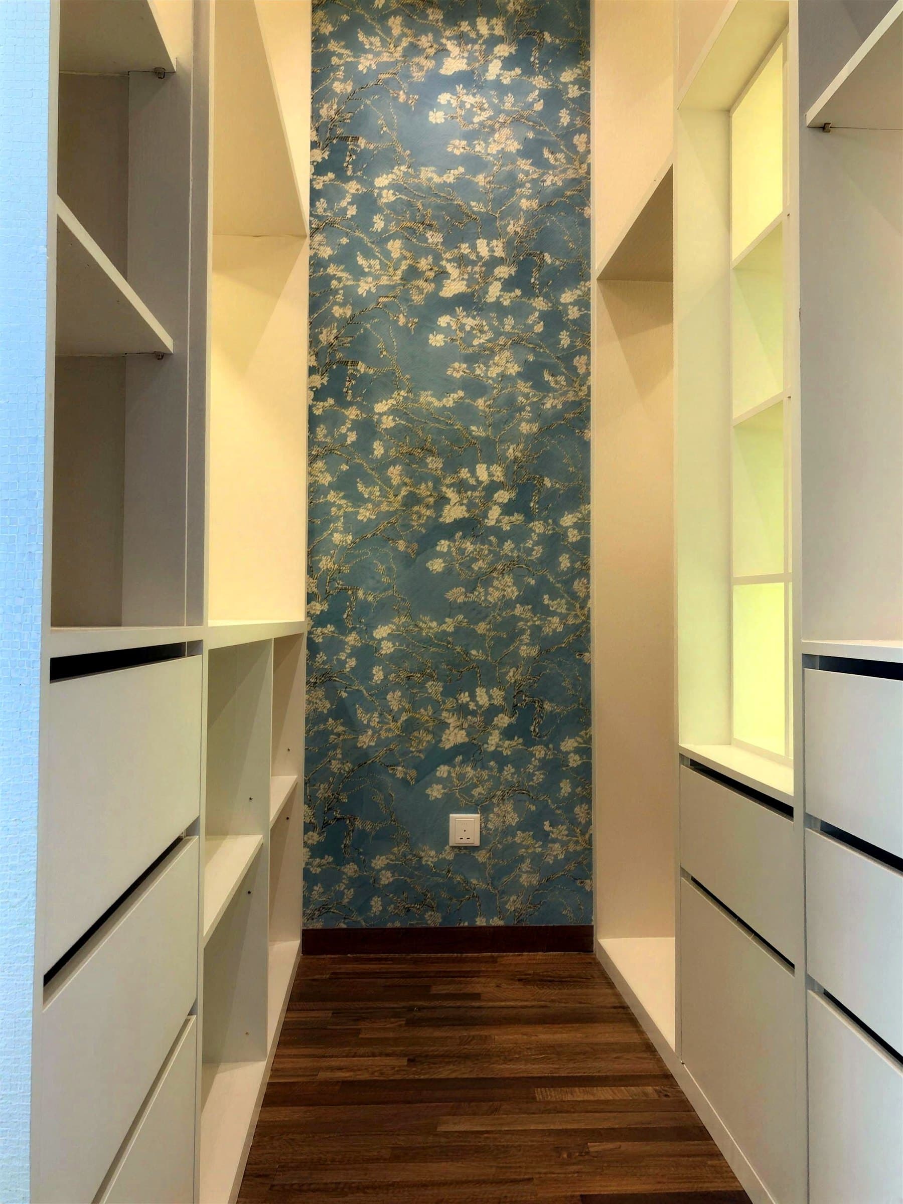 Built-in open wardrobe with lit shelves and Almond Blossom wallpaper inside